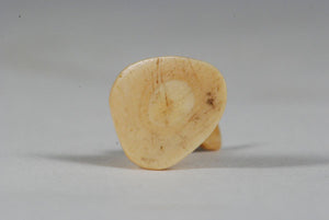 A miniature ancient Inuit game piece carved from walrus ivory